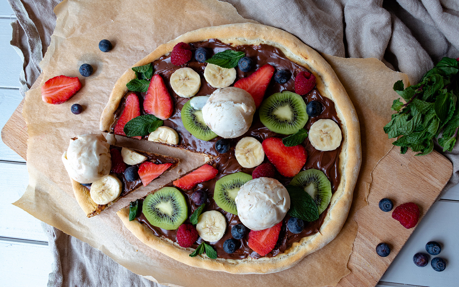 Süße Pizza mit frischen Früchten und Eis (vegan)